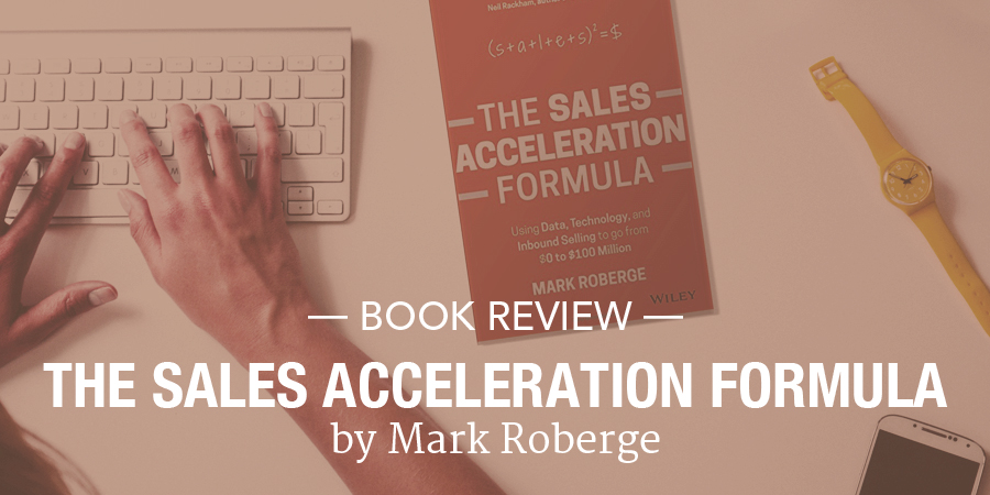 Person typing on a keyboard next to a copy of The Sales Acceleration Formula. Overlay text says Mark Roberge Wiley - Book Review - The Sales Acceleration Formula by Mark Roberge