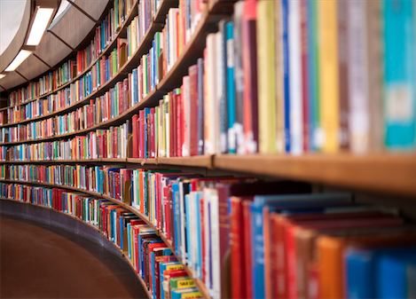 Curved wall of colorful books at a library.