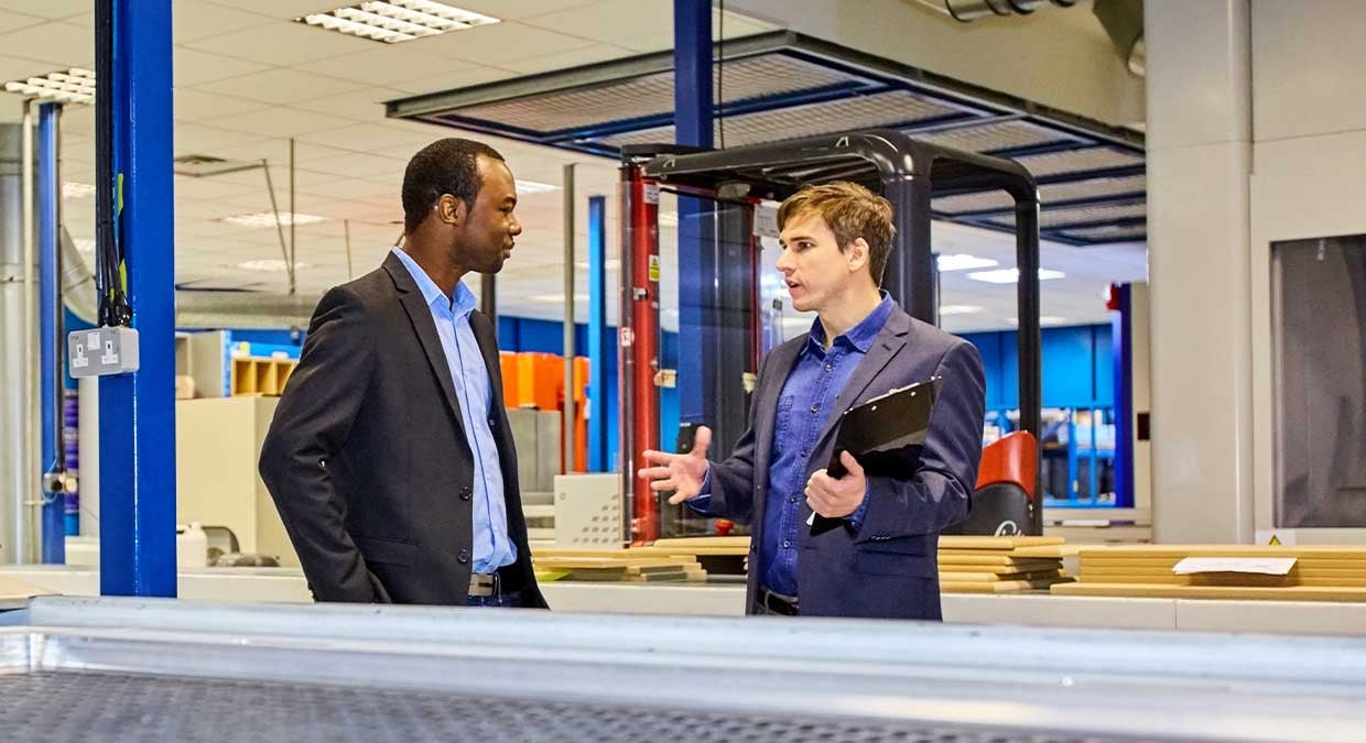 Two people talking on a manufacturing floor