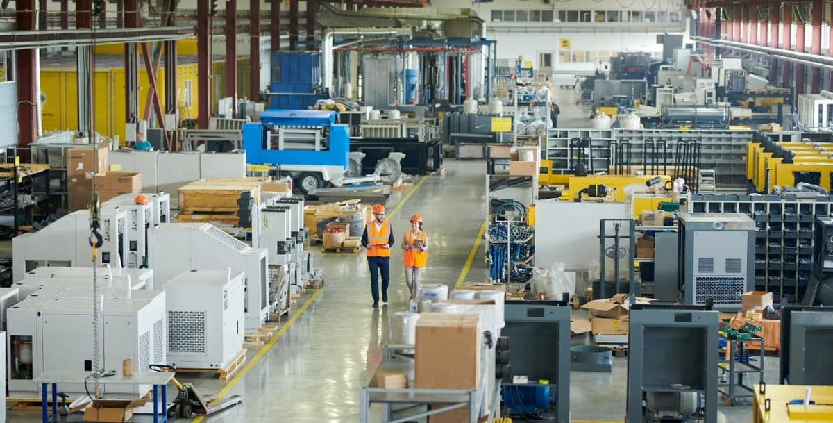 Colleagues walking manufacturing plant floor discussing current challenges