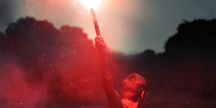 Person holding up a burning flare.
