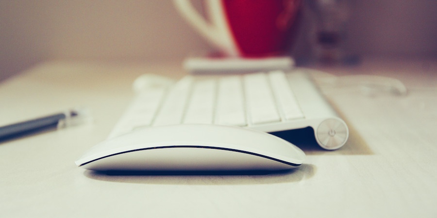 Apple keyboard and mouse on a table