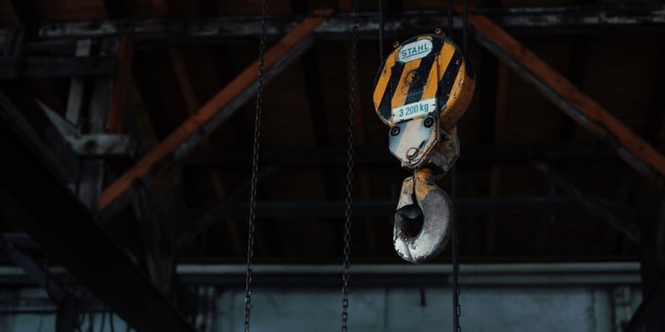 A 3200 kg crane hook inside of an industrial warehouse.