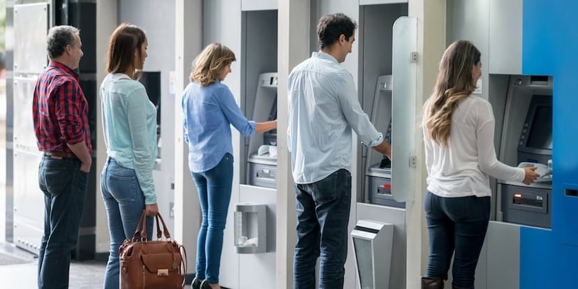 People taking out money at ATMs