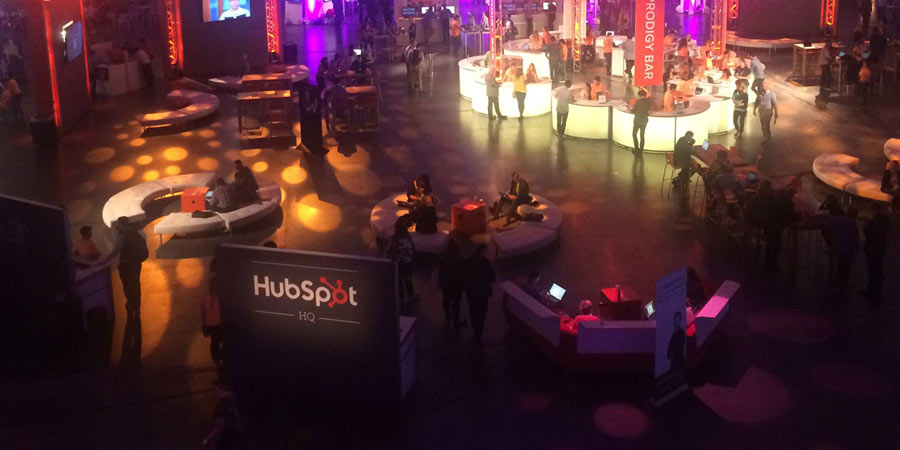 HubSpot Inbound 2014 conference HQ location. There are several people sitting on curved padded benches and a bar in the background.