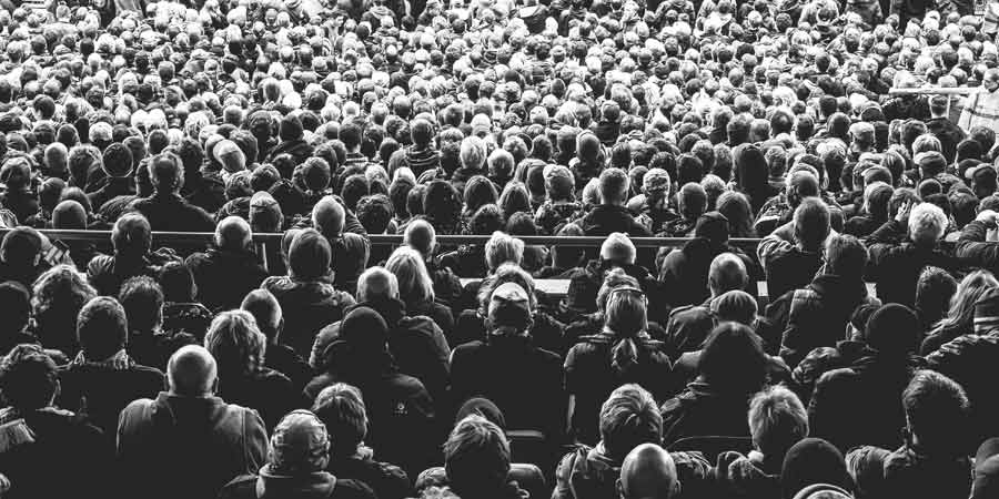 Large crowd of people looking away from the camera in black and white.