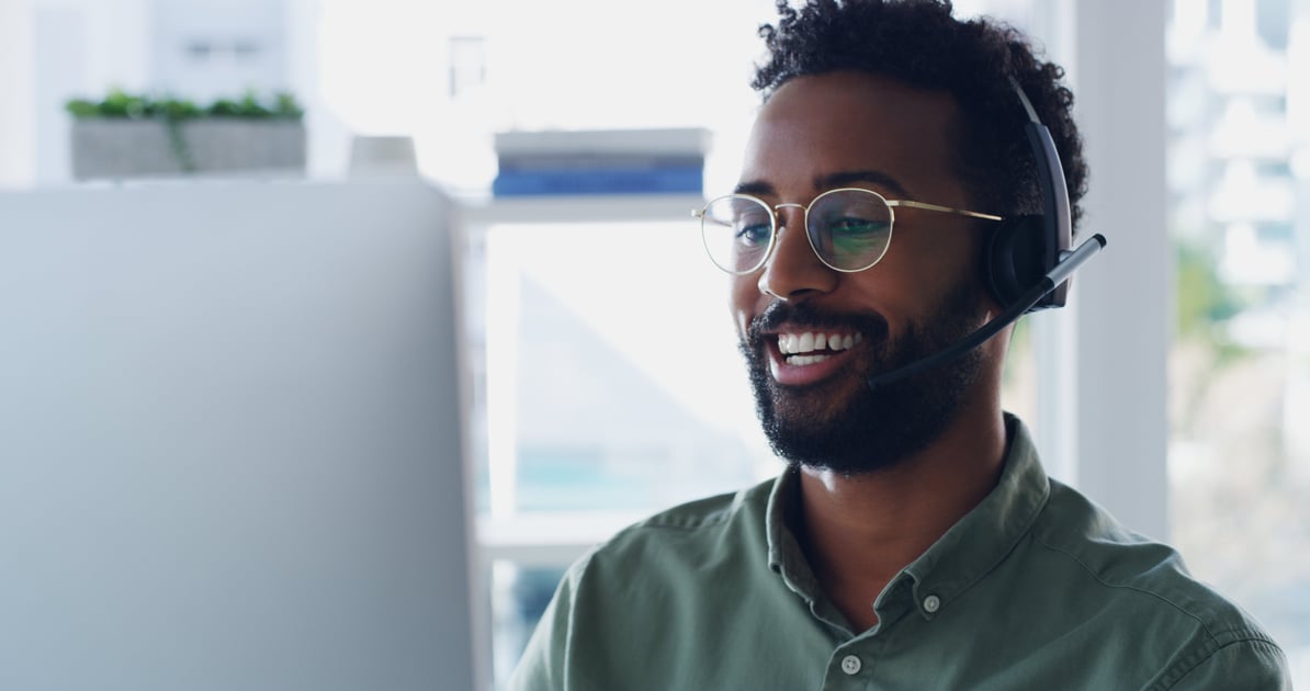 man wearing headset sitting at a computer