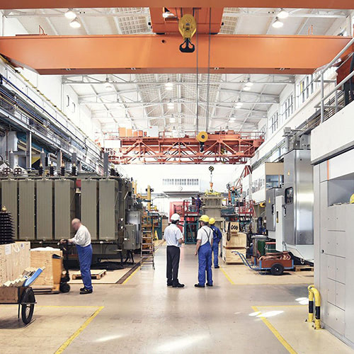 A factory floor with workers wearing hard hats.