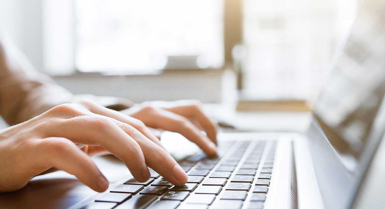 close_up_of_hands_typing_on_laptop