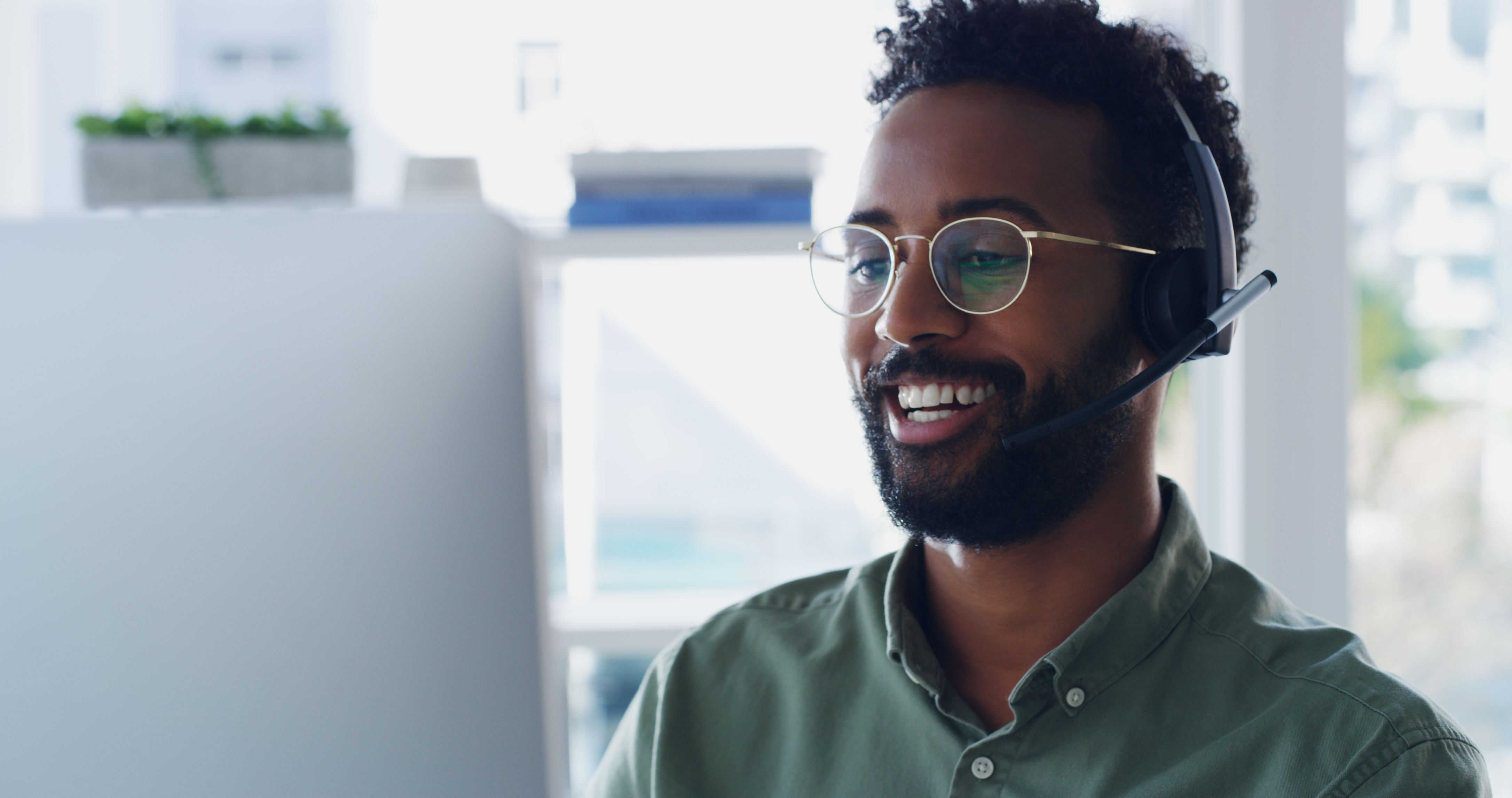 man wearing headset sitting at a computer